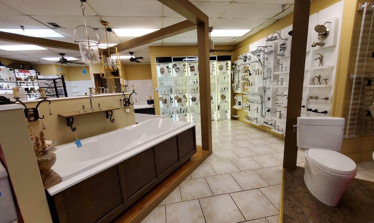 Image of showroom featuring a bathtub and display of sink faucets and shower heads.