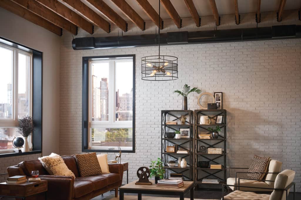 Transitional interior design living room with exposed wood beam, white brick wall, and modern furnishings