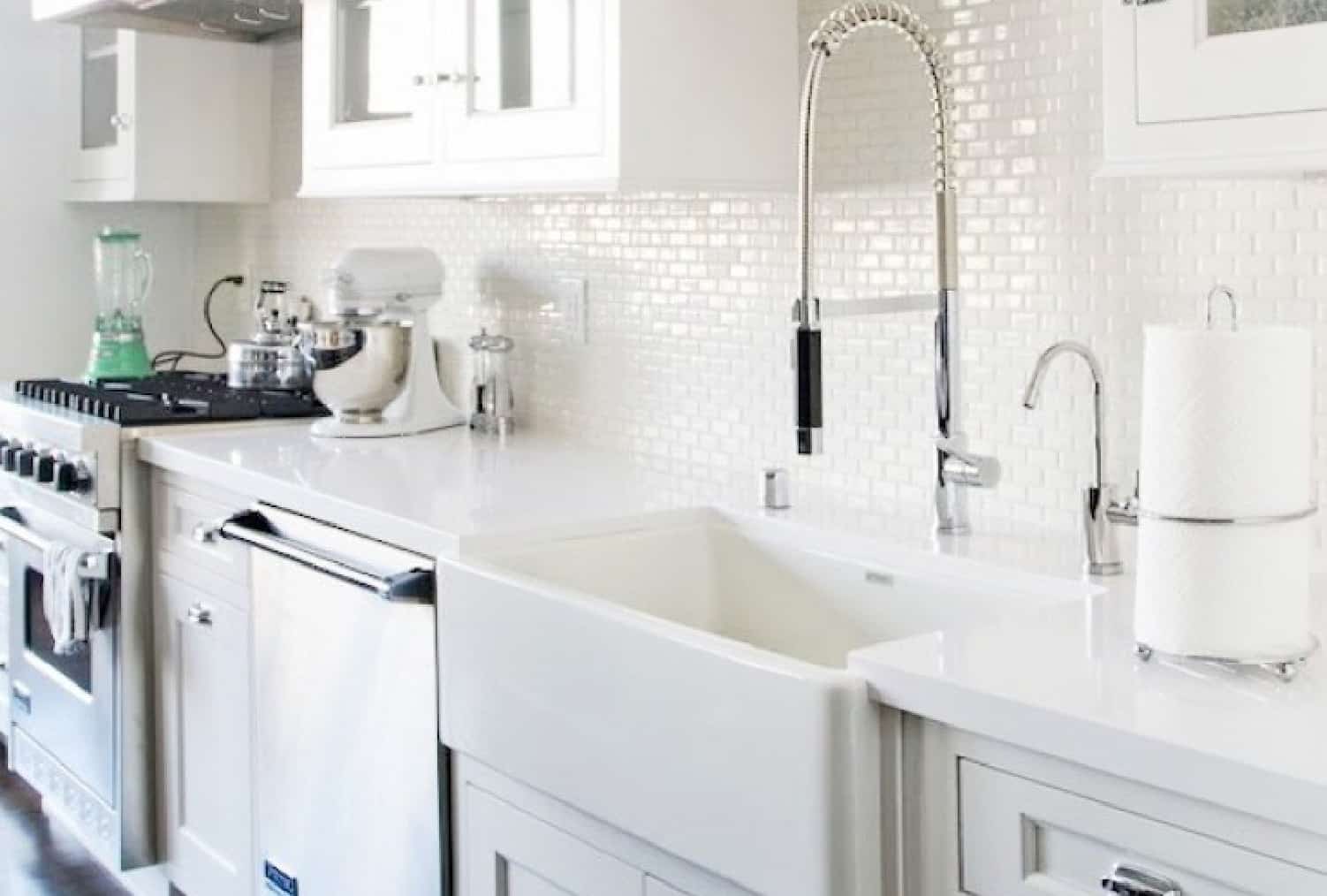 this all-white kitchen with a basin sink, pull-down faucet and mini-tile backsplash offers the perfect kitchen upgrade ideas for modern farmhouse lovers.