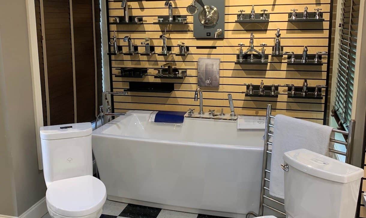Showroom display featuring faucets, sink handles, bathtub, and toilet