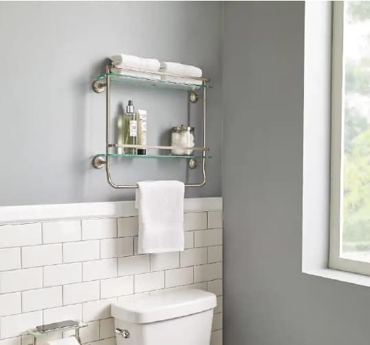 A towel and accessories rank hanging above the toilet is the perfect space saver for small or minimalistic bathrooms. Get more bathroom design ideas at Coburn's Kitchen & Bath Showroom.