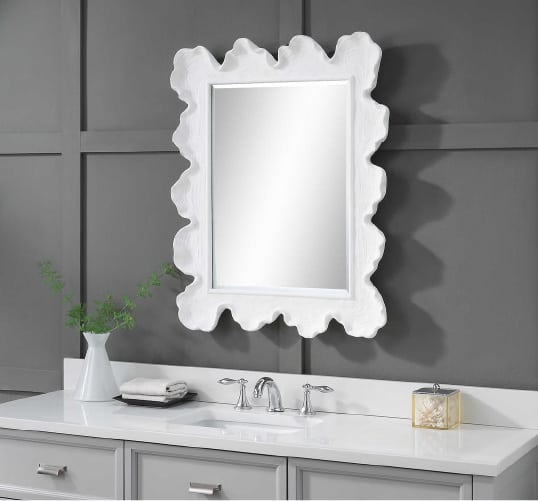 An elegantly framed mirror that pops in a bathroom surrounded by minimalistic grey and white accents. Explore more bathroom renovation inspiration at Coburn's Kitchen & Bath Showroom