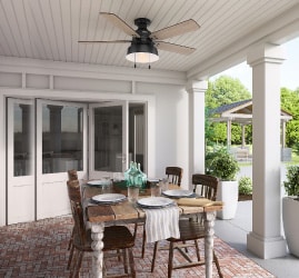 an outdoor cooking area with a dining table and overhead fan for outdoor entertaining. Get more backyard makeover ideas at a Coburn's Showroom near you.