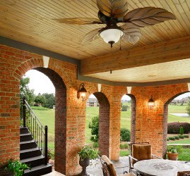 an elegant outdoor entertainment area including classy brick archways, a leaf-designed fan and dining area. Get more diy backyard ideas at a Coburn's Showroom near you.
